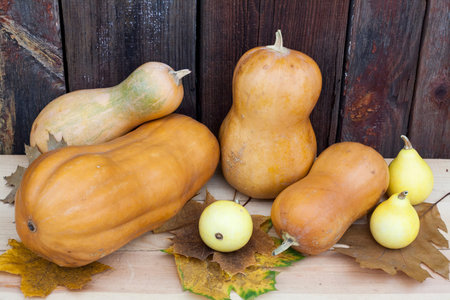 Autumn still life with pumpkins and autumn leaves on old wooden background