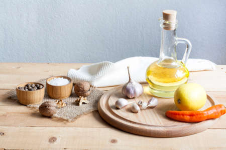 Food ingredients. Oil, eggs, garlic, limon, walnuts and herbs on wooden table. Wooden board and napkin.の写真素材