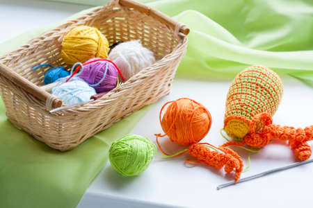 Making of handmade colorful crochet toys sweets key ring with skein on wooden table. Selective focus.の写真素材