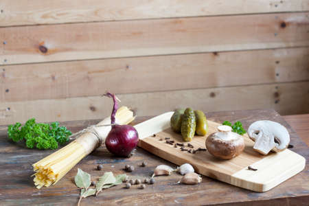 Long Noodles Linguine, pickled cucumbers gherkins, Champignon mushrooms, herbs, spices and vegetables on wooden tableの写真素材