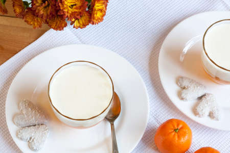 Vanilla and orange Panna Cotta in the cup on white saucerの写真素材