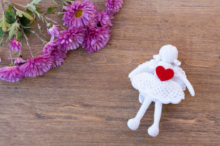 Valentines day hearts and angel and flowers on wooden tableの写真素材