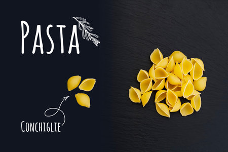 Uncooked Italian pasta Conchiglie on black slate stone background with white lettering, top view