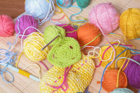 Colorful clews yarn and crochet hook on wooden background. Toned and processing photosの写真素材