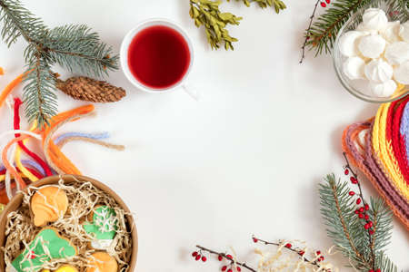 Christmas and New Year composition. Christmas cookies, fir tree and boxwood  branches, cup of hot tea, checkered scarf. Flat lay on white background, top viewの写真素材