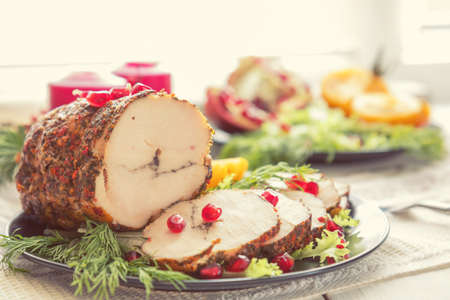 Christmas holiday dinner. Stuffed chicken breast with herbs, tomatoes, pomegranate and spices against holiday background. Coloring and processing photo.の写真素材