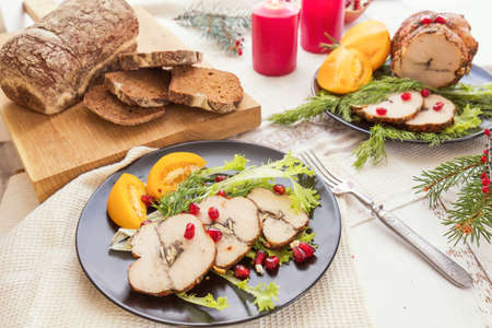 Christmas holiday dinner. Stuffed chicken breast with herbs, tomatoes, pomegranate and spices against holiday background. Coloring and processing photo.の写真素材