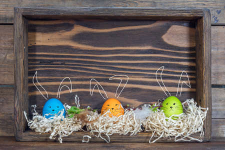 Easter eggs with bunny ears in the nests in boxesの写真素材