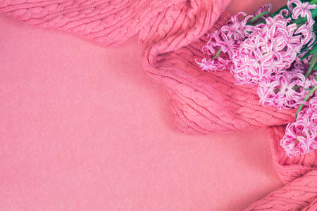 Beautiful spring holiday background. Fresh white hyacinth and pink woven scarf on pink copy space groundwork.の写真素材