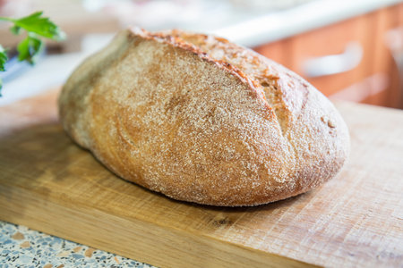 Fresh homemade bread on wooden board. Fresh green dill and parsley.  Shallow depth of field....