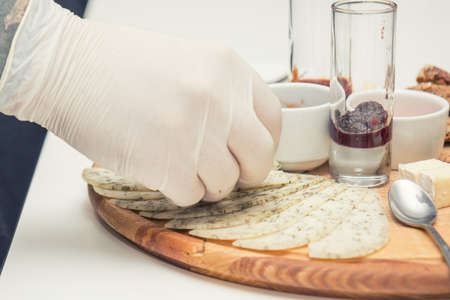 Different delicious cheeses brie, blue cheese, rosette of swiss cheese Tete de Moine, cheese of thyme with nuts and dressing on wooden round board. Low key tone.の写真素材