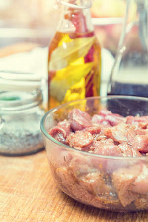 Raw pork neck meat cut in slices with marinated in glass bowl  in a modern kitchen. Shallow depth of field. Tonedの写真素材