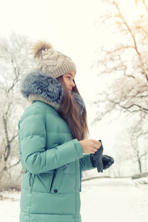 Young smiling girl portrait in winter snow park. Close up. Toned and processing photo