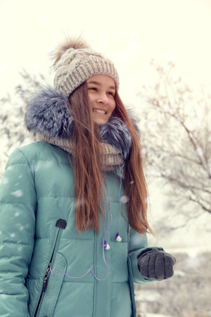 Young smiling girl portrait in winter snow park. Close up. Toned and processing photo