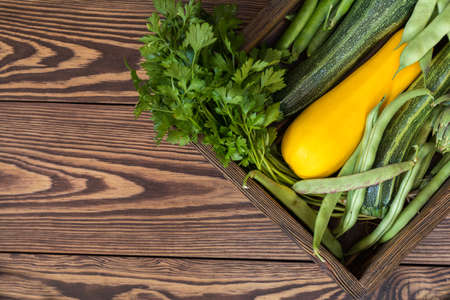 Fresh organic green vegetables wooden floor with copy space. Green and yellow vegetables background. Healthy eating background. Vegetarian food, organic food.の写真素材
