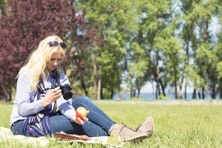 Professional woman photographer taking outdoor with prime lens, during a sunny day in the spring...