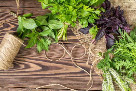 Fresh organic green herbs wooden floor with copy space. Green and violet plants background. Healthy eating background. Vegetarian food, organic food.の写真素材