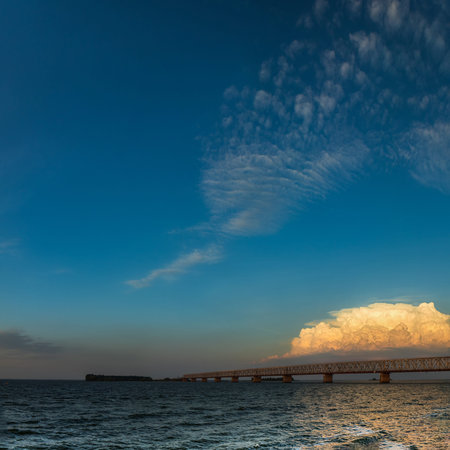 Stunning sunset colors over river with bridge in a summer evening. Dramatic clouds. Toned.