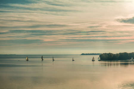 Sunrise over the river with yachts on a calm water surface in the summer timeの写真素材