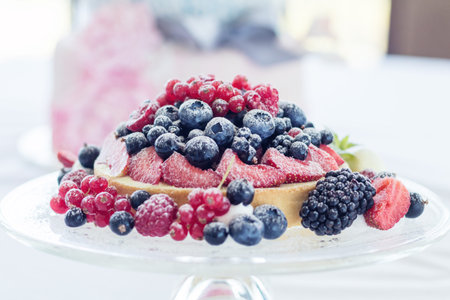  Tasty berry pie with fresh berries on a glass plate. Light background. Shallow depth of field