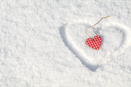 Beautiful valentine holiday background with checkered motley heart on white snow surface.