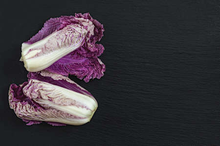 Two blue napa cabbages on black stone surface. Top view, copy space.の写真素材