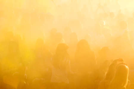 People dancing during Colorful Holi Festival. Blurred sunny sunset multicolor background.の写真素材