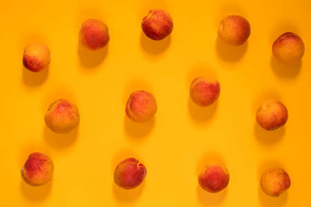 Many juicy beautiful amazing nice peaches on yellow surface. Beautiful food art background. Top view, copy space.の写真素材