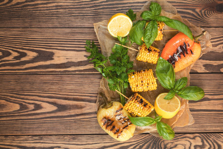Corn baked in olive oil, with pepper, salt and basil on blue dish on a black stone surface....