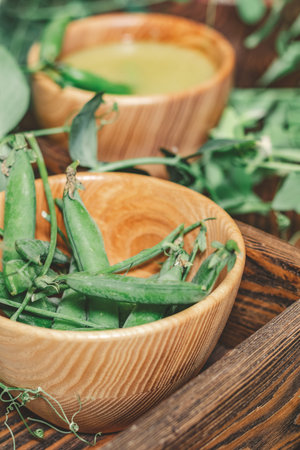 Pods of green peas and pea on a dark wooden surface. Vintage wooden surface for design with...