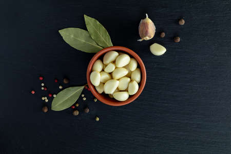 Fresh garlic heads, cloves set on a black stone surface, top view, copy space, copy space for text.の写真素材