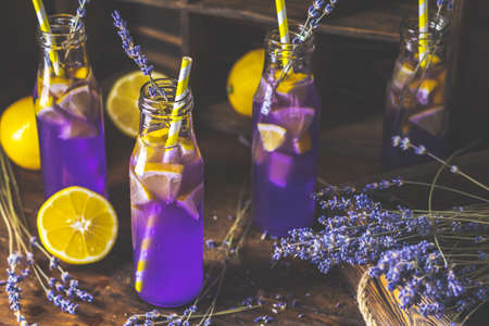 Fresh violet cocktail with lemon, ice and lavender, drink bottles glass on a  dark old rustic style, selective focus, shallow depth of the field.の写真素材