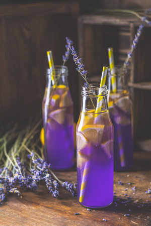 Fresh lavender violet cocktail with lemon and ice, drink bottles glass on a  dark old rustic style, selective focus, shallow depth of the field.の写真素材