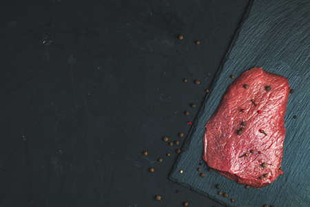 Fresh raw meat beef steak with ingredients for cooking spices, thyme on dark background, top view, copy space for you textの写真素材