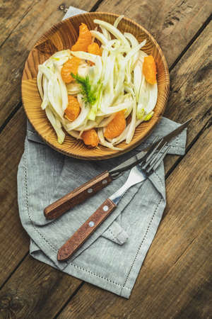 Traditional sicilian italian salad with fennel and tangerine. Fennel and orange citrus salad, on wooden plate. Modern, light, raw, veg cuisine. Winter salad.の写真素材