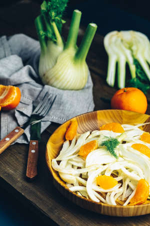 Traditional sicilian italian salad with fennel and tangerine. Fennel and orange citrus salad, on wooden plate. Modern, light, raw, veg cuisine. Winter salad.の写真素材
