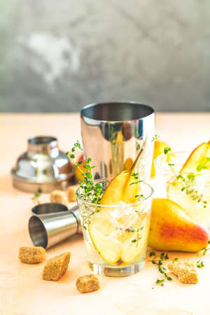 Pear mulled cider with thyme, brown sugar and ice  on light concrete surface tableの写真素材