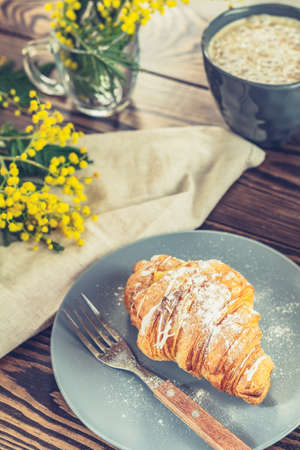 Continental traditional breakfast with croissants and coffee served on wooden table background empty copy space. French breakfast.の写真素材