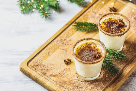 Eggnog with cinnamon and nutmeg for Christmas and winter holidays. Homemade eggnog in glasses on...