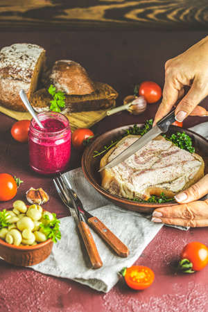 Woman cutting preparing tasty baking pork lard bacon fatback with black pepper, other herbs and spices in ceramic dish. Traditional Ukrainian, Hungarian, Polish or other Eastern Europe national dishの写真素材