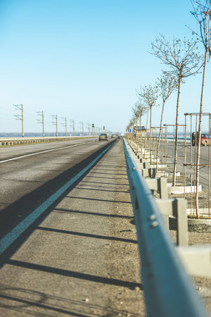 Autumn sunny beautiful day on outside city highway. Shallow depth of the field. Rail along road....