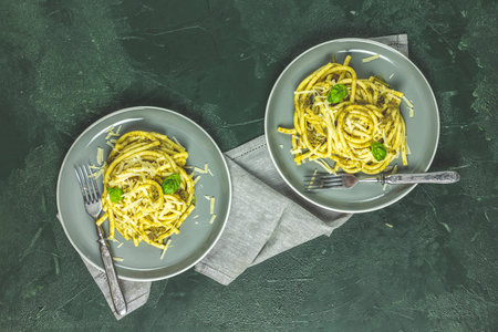 Spaghetti pasta bucatini with pesto sauce and parmesan. Italian traditional perciatelli pasta by...