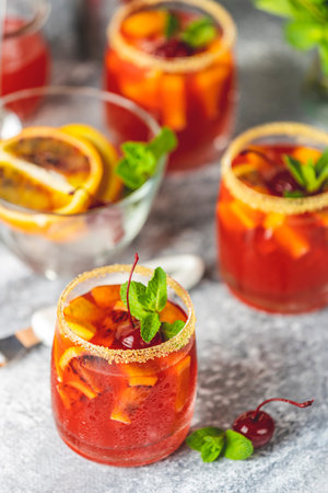 Italian cocktail with orange slices and ingredients on light gray stone table. Summer drink,...