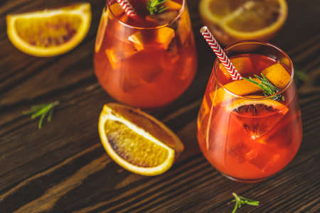 Milano alcoholic cocktail with red bitter, dry white wine, soda, red orange and ice. Dark wooden background, selective focusの写真素材