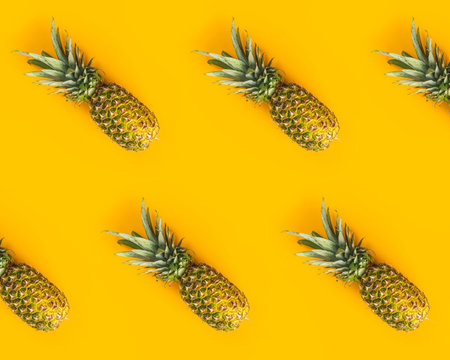 Fresh ripe pineapples on yellow background. Summer concept. Creative flat lay with copy space. Top...