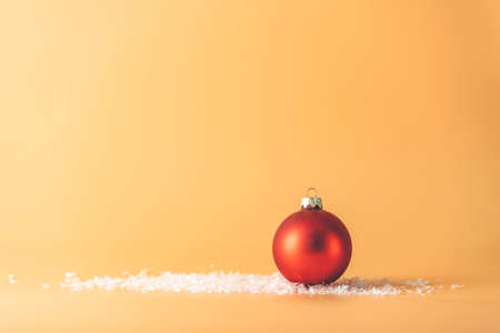 Christmas ball. Christmas background with red ball on yellow. Merry christmas greeting card. Winter holiday xmas theme. Happy New Year. Space for textの写真素材