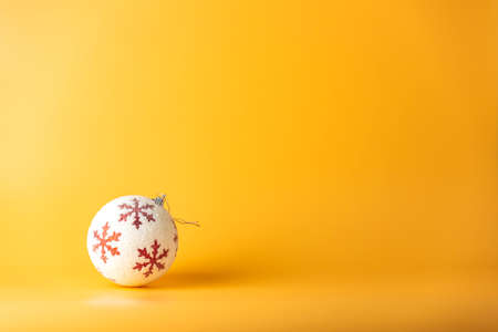Christmas ball. Christmas background with white and red ornaments on yellow. Merry christmas greeting card. Winter holiday xmas theme. Happy New Year. Space for textの写真素材