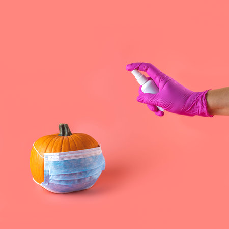 Natural organic pumpkin vegetable with protective medical face mask and Hand in blue glove hold...