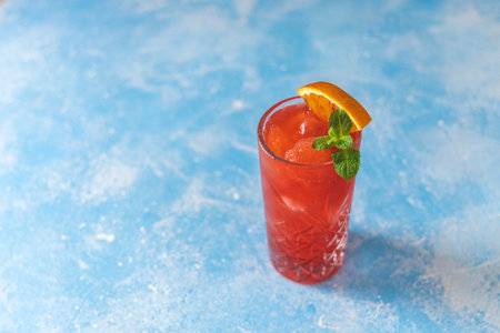 Red cocktail with blood oranges and mint on the blue rustic background. Selective focus. Shallow depth of field.の写真素材