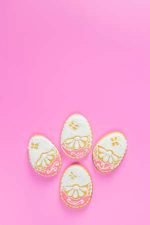 Beautiful Easter background or greeting card with colored pink gingerbread eggs on pink surface background. Happy Easter. Top view, flat layの写真素材
